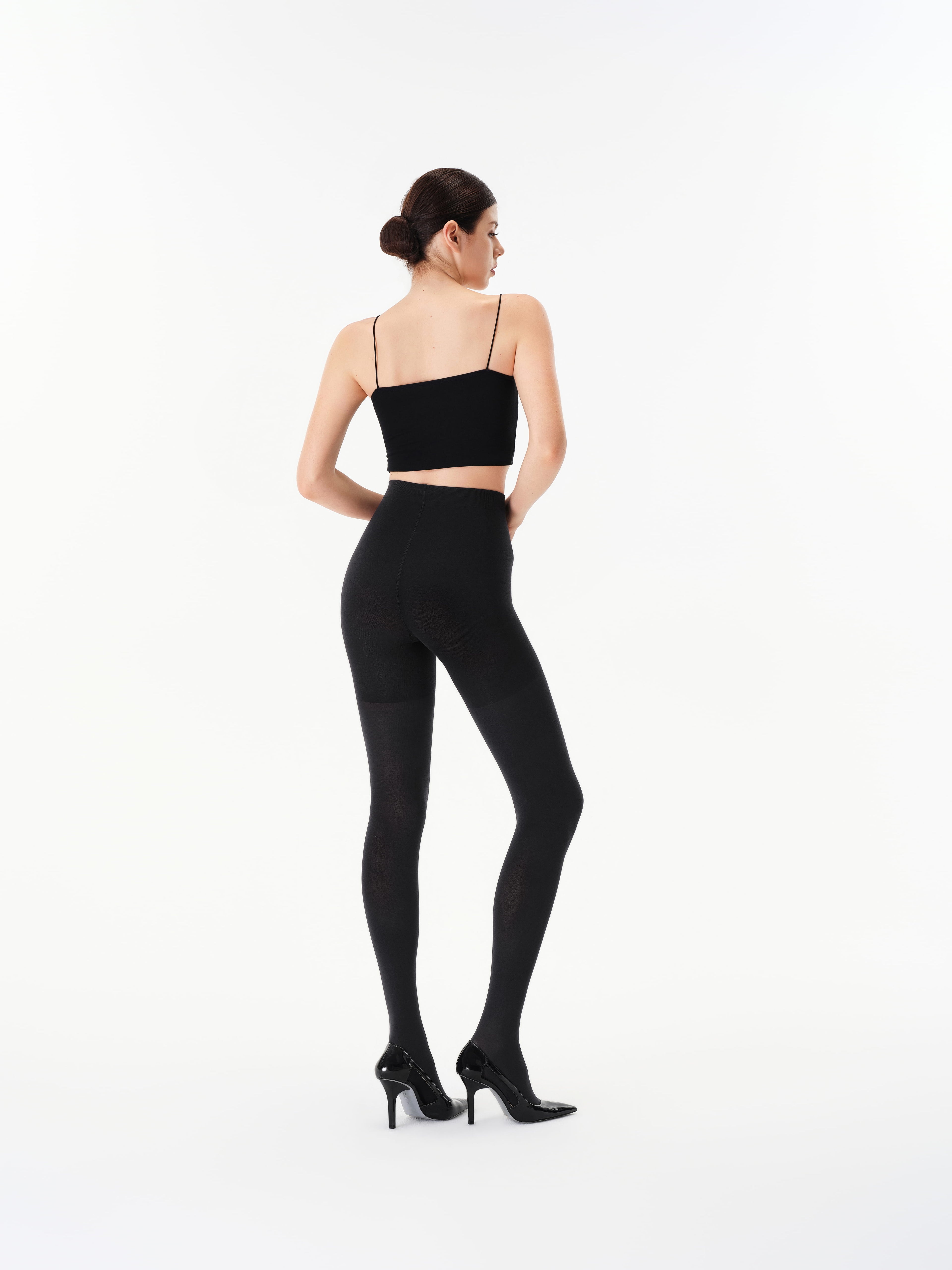 Back view of a model wearing Yirane black opaque 80 denier matte tights.
