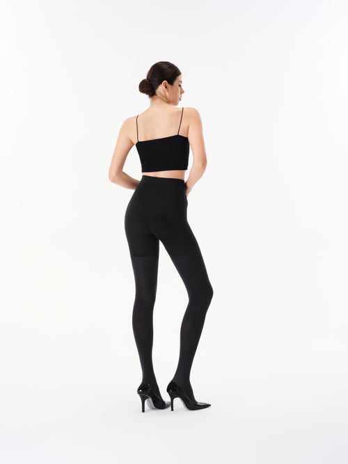 Back view of a model wearing Yirane black opaque 80 denier matte tights.