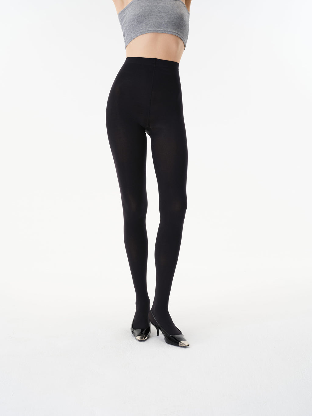Front detail showing the high-rise waistband and opaque finish of Yirane black tights.
